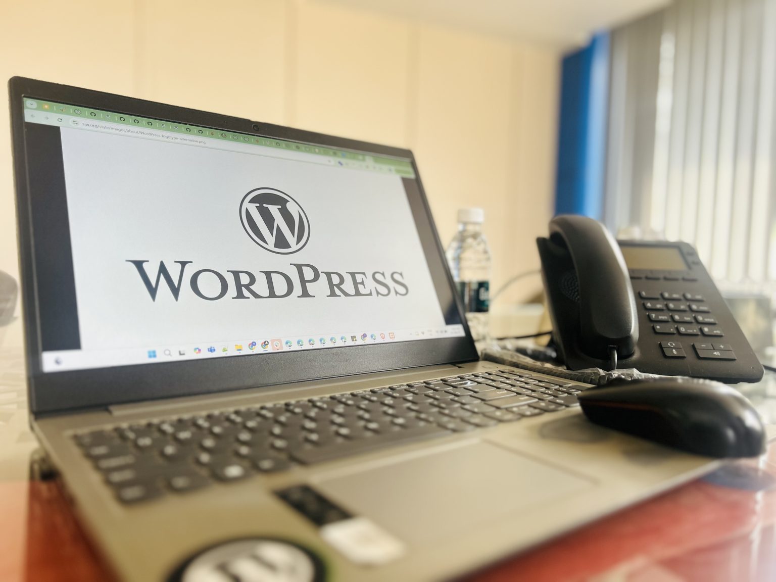 桌面上显示WordPress标志的笔记本电脑与电话