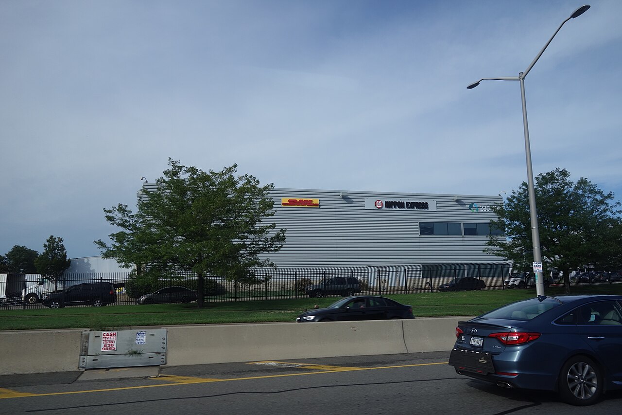 美国New York JFK机场北侧DHL与Nippon Express使用的物流建筑和卡车,2018年资料照片