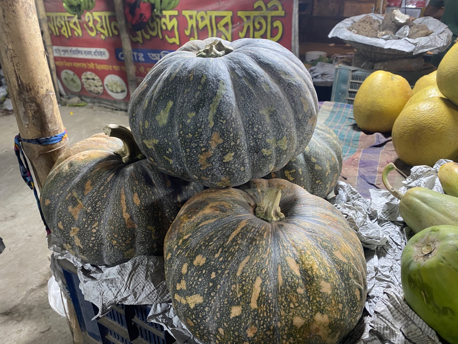 市场摊位上的南瓜及周边果品资料照片