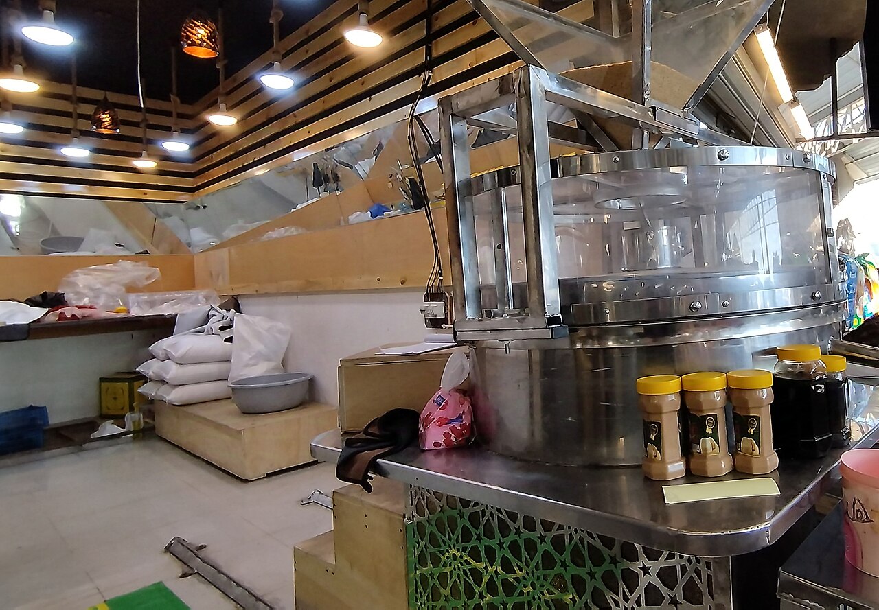 伊拉克Mosul零售加工场所的芝麻酱研磨设备与瓶装商品，2025年资料照片
