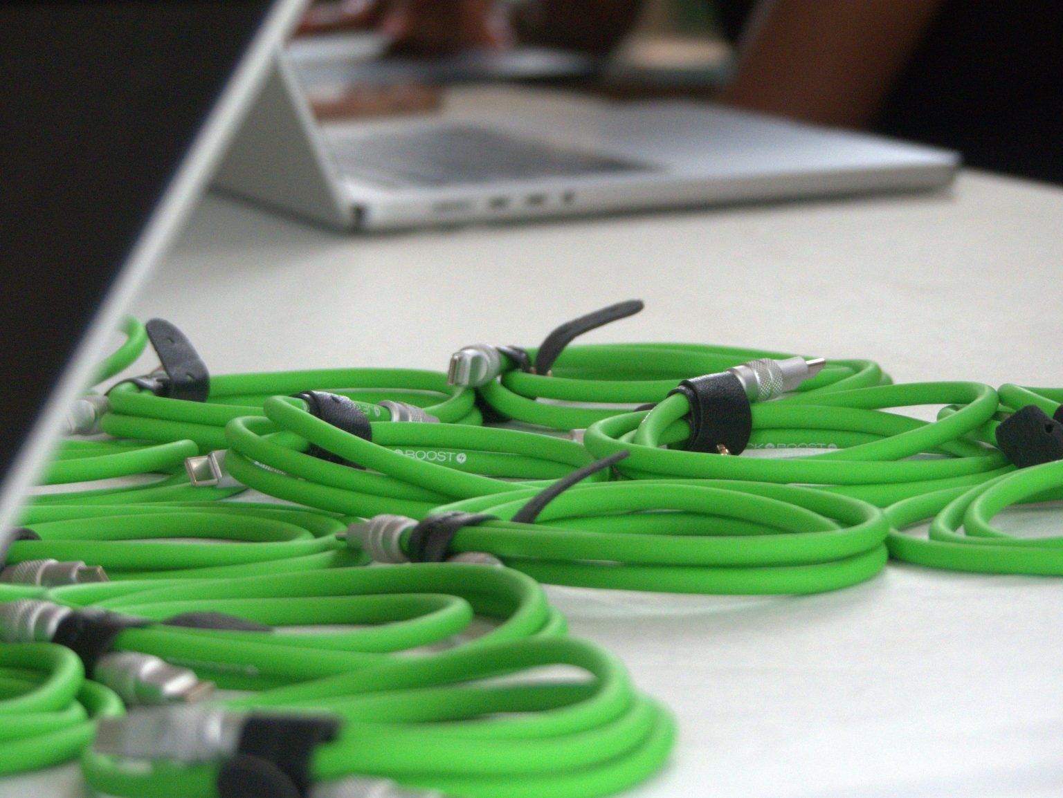 WordCamp Masaka 2025 活动桌上的绿色 USB-C 线缆