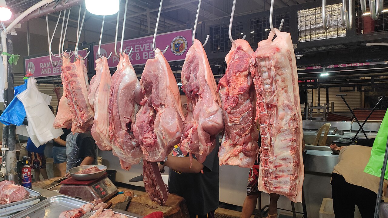 菲律宾伊洛伊洛市公共市场悬挂销售的鲜猪肉（真实资料图）