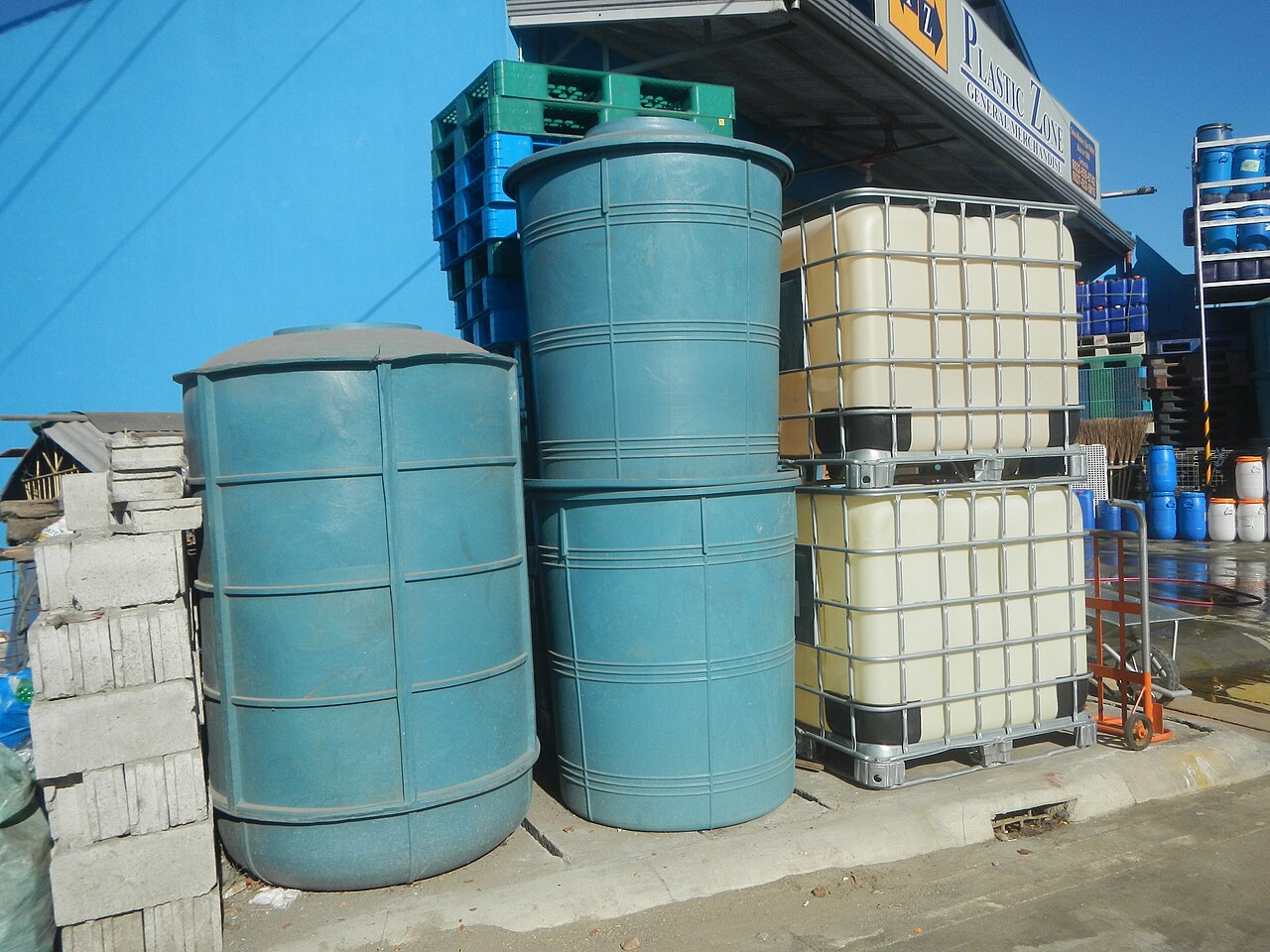 供应商室外陈列的不透明塑料桶及笼式容器；不推断桶内物料
