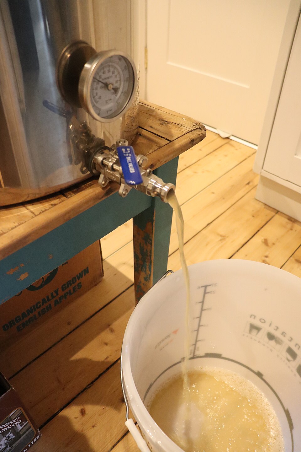 家庭酿造中接收液体的塑料发酵桶；仅说明图示容器用途，不暗示化工物料