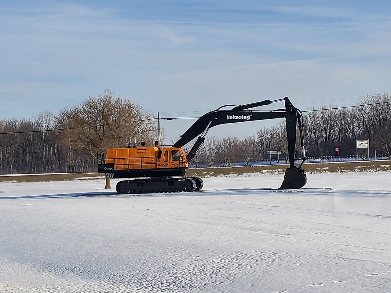 雪地停放的履带式挖掘机资料照片