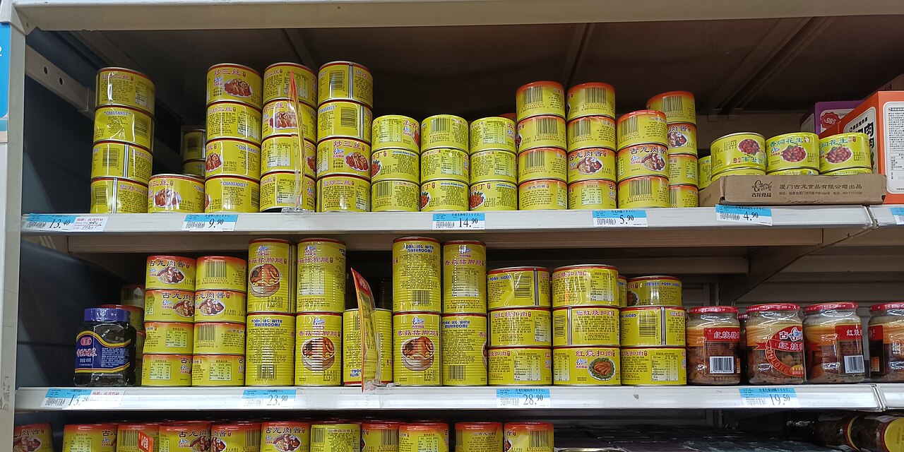 商店货架上带蘑菇、蔬菜等图示标签的密封罐头资料照片，不据此认定每个商品均属于加拿大本次措施范围